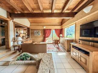 Experience rustic elegance in this stunning property, featuring a warm, inviting interior with exposed wooden beams and paneling.