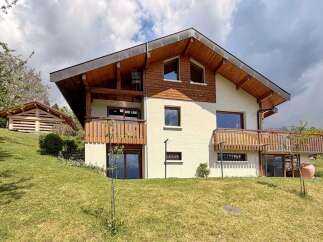 This stunning property boasts a beautiful exterior with wooden accents and a charming balcony.