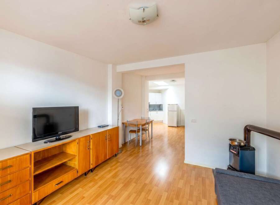 Discover this charming property featuring a cozy living space with a modern TV and stylish wooden cabinetry.