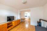 Discover this charming property featuring a cozy living space with a modern TV and stylish wooden cabinetry.