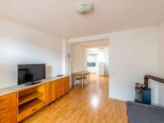 Discover this charming property featuring a cozy living space with a modern TV and stylish wooden cabinetry.