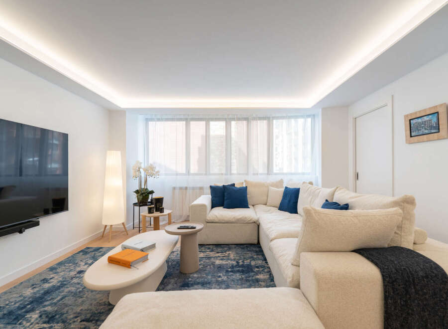 Experience modern living in this stunning property! The spacious living room features a large, comfortable sectional sofa, perfect for relaxing.