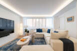 Experience modern living in this stunning property! The spacious living room features a large, comfortable sectional sofa, perfect for relaxing.