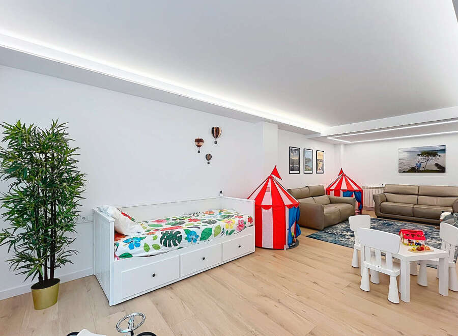 This spacious room is designed for family fun and relaxation, featuring a comfortable daybed with playful bedding and two circus-themed tents.