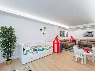 This spacious room is designed for family fun and relaxation, featuring a comfortable daybed with playful bedding and two circus-themed tents.