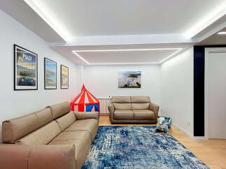 This spacious living room features a large, comfortable sectional sofa perfect for family gatherings.