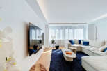 Experience modern living in this bright and airy living room, featuring a large sectional sofa adorned with plush blue accent pillows.