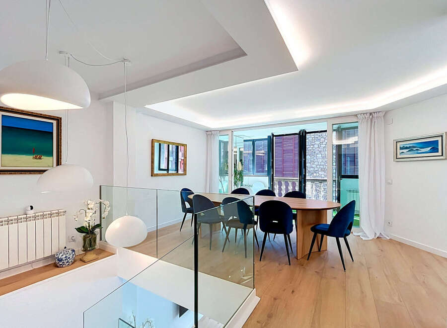 Experience modern living in this stunning dining area, featuring a sleek oval dining table surrounded by plush navy velvet chairs.