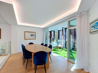 Experience modern living in this elegant dining area, featuring a sleek oval wooden table surrounded by plush navy velvet chairs.