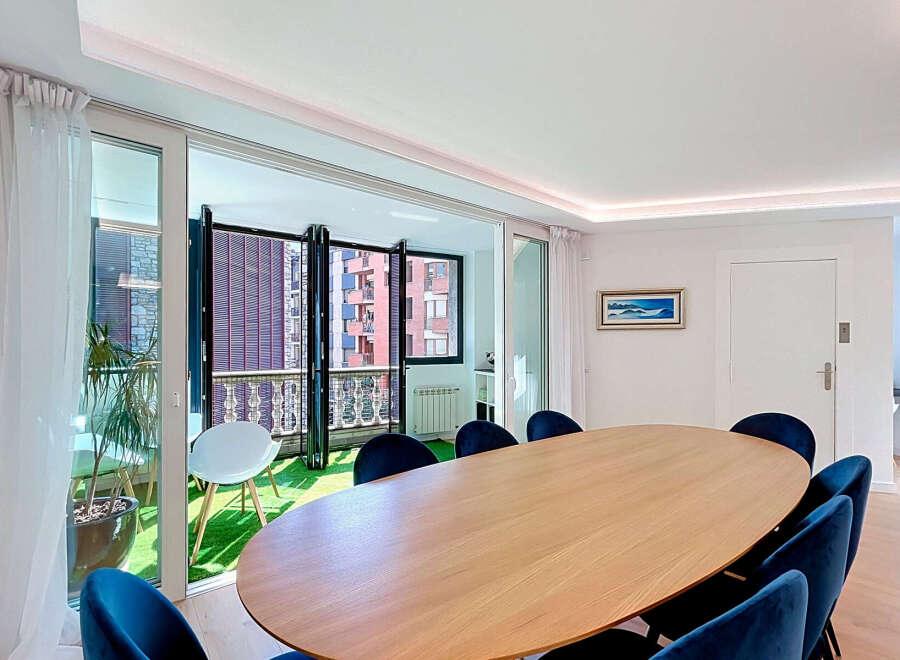 Experience modern living in this elegant dining area, featuring a sleek oval wooden table surrounded by plush navy velvet chairs.