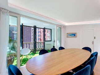 Experience modern living in this elegant dining area, featuring a sleek oval wooden table surrounded by plush navy velvet chairs.