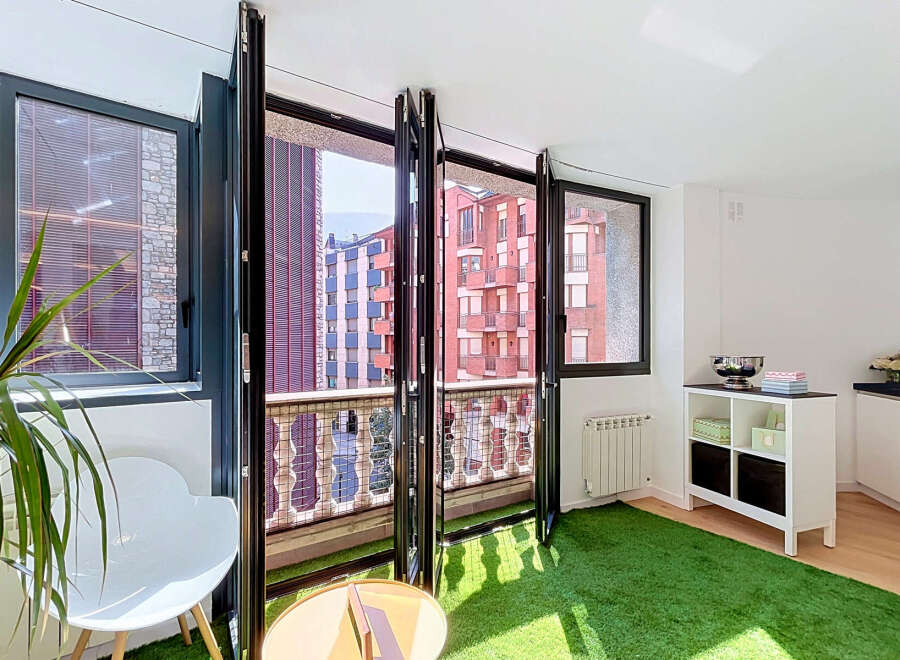 Experience seamless indoor-outdoor living with this modern apartment featuring expansive bi-fold doors that open onto a charming balcony.