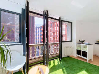 Experience seamless indoor-outdoor living with this modern apartment featuring expansive bi-fold doors that open onto a charming balcony.