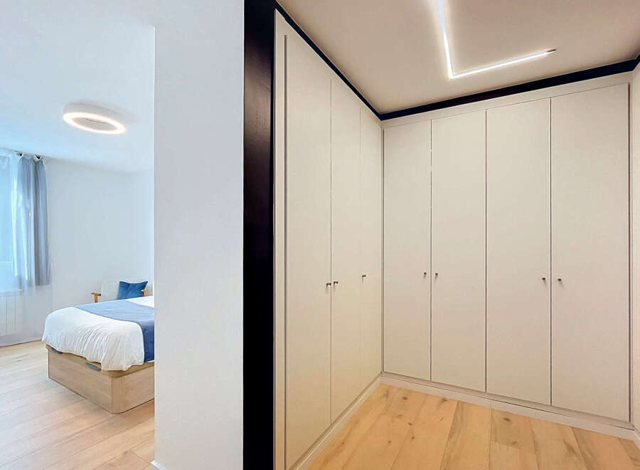 Discover modern living in this beautifully appointed bedroom, featuring a minimalist design with a comfortable bed and ample built-in wardrobe space.