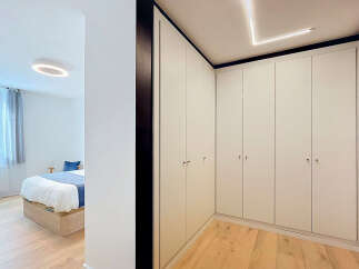 Discover modern living in this beautifully appointed bedroom, featuring a minimalist design with a comfortable bed and ample built-in wardrobe space.