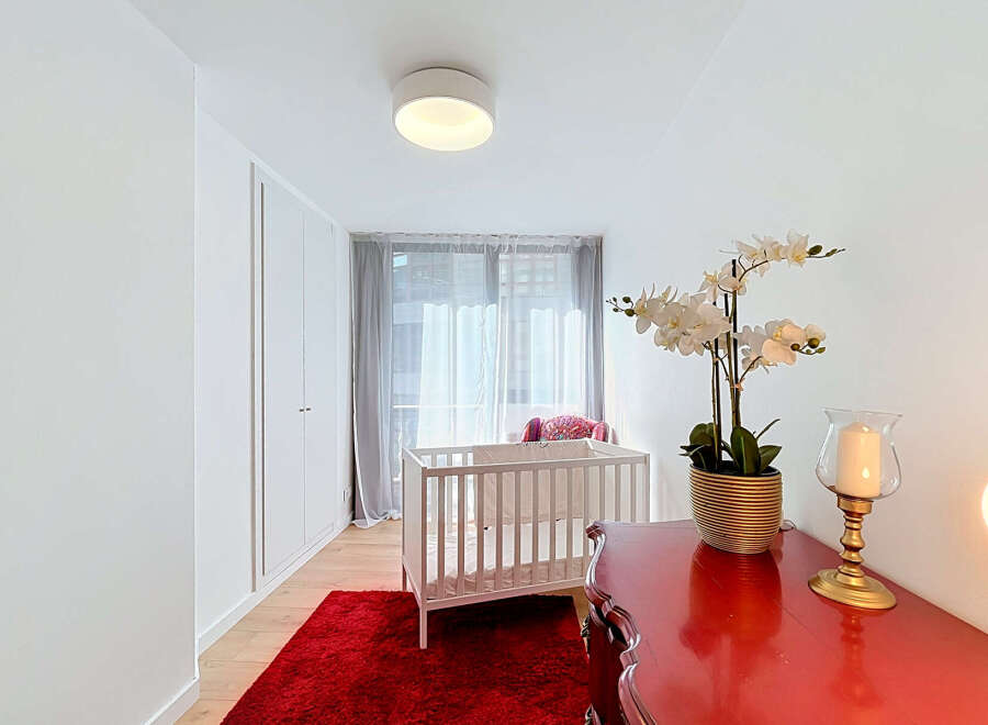 Discover a serene nursery space featuring a classic white crib adorned with soft bedding, perfect for a little one.