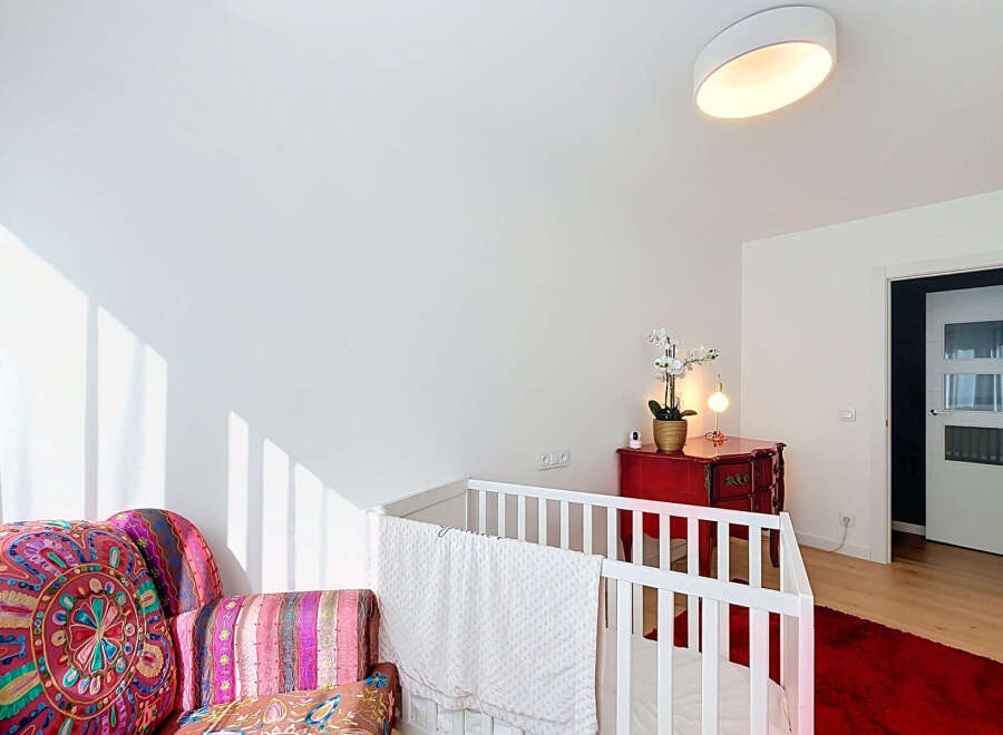 This charming nursery features a cozy crib adorned with a soft white blanket, perfect for a little one's peaceful slumber.
