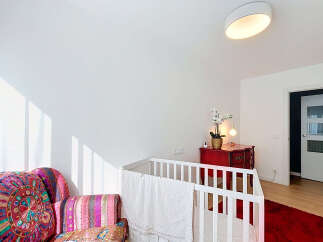 This charming nursery features a cozy crib adorned with a soft white blanket, perfect for a little one's peaceful slumber.
