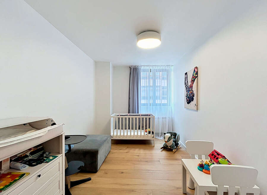 This charming nursery features a comfortable crib and a changing station, perfect for a growing family.