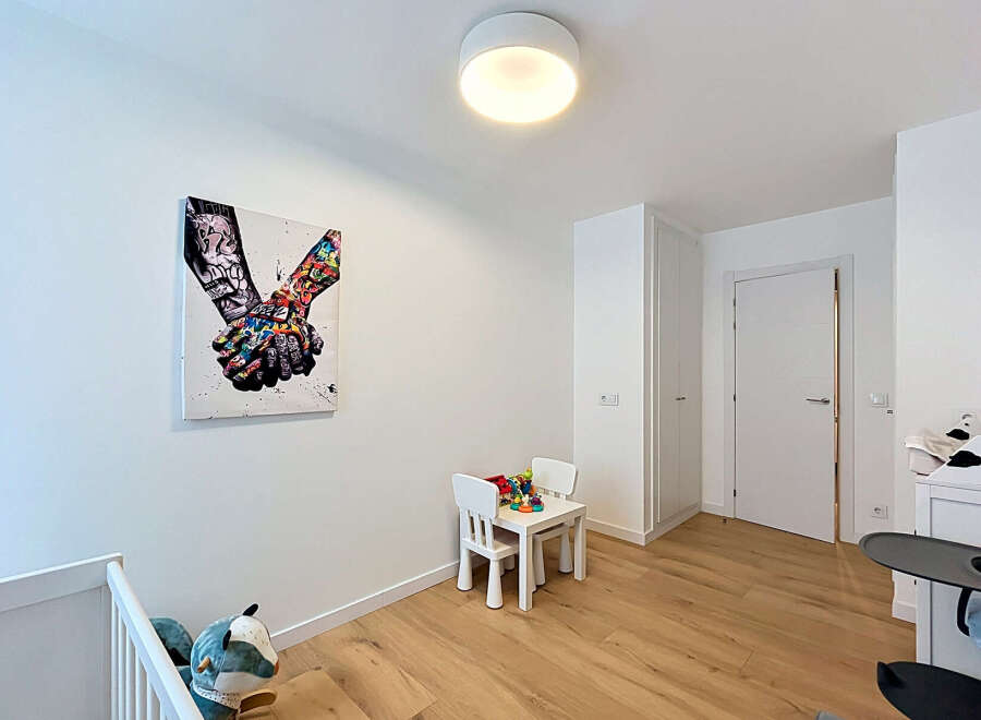 Discover this charming room featuring a vibrant piece of wall art and a cozy children's play area with a small table and chairs.