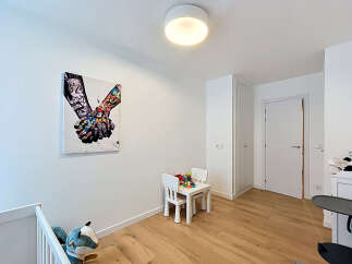 Discover this charming room featuring a vibrant piece of wall art and a cozy children's play area with a small table and chairs.
