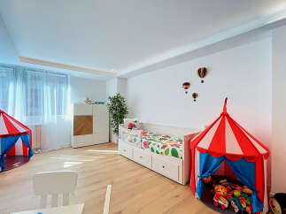 This charming children's bedroom features a playful circus-themed tent and a comfortable daybed adorned with a vibrant floral comforter.
