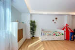 This charming children's room features a comfortable white daybed with colorful floral bedding, perfect for a child's sanctuary.