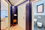 Step into a stylish entryway featuring a striking deep purple accent wall and elegant white door.
