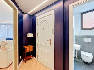Step into a stylish entryway featuring a striking deep purple accent wall and elegant white door.