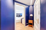 Step into this stylish apartment featuring a striking navy blue hallway that leads to a bright and modern living space.