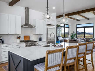 Step into luxury with this stunning kitchen, featuring sleek white cabinetry, a modern stainless steel range hood, and a spacious island perfect for entertaining.