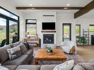 Step into luxury with this stunning living room, featuring a cozy fireplace and a large flat-screen TV, perfect for relaxing evenings.