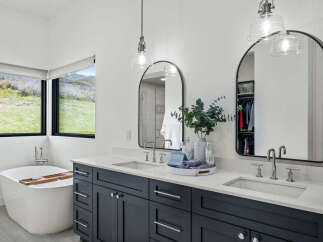 This stunning bathroom boasts a modern design with a luxurious soaking tub and a sleek double vanity.