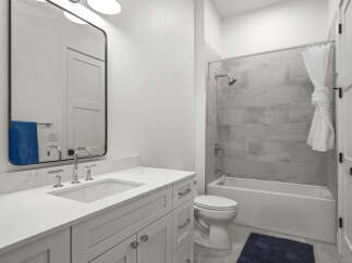 Step into this modern bathroom, featuring a sleek vanity with ample storage and a stylish mirror.