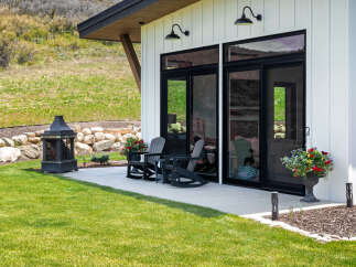 Experience the epitome of outdoor living with this stunning property, featuring a beautifully designed patio and lush green lawn.