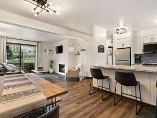 Experience modern living in this stunning property, featuring a cozy fireplace and a sleek kitchen with a breakfast bar.