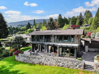 This stunning property boasts a modern design with expansive windows and multiple levels, offering breathtaking views of the surrounding natural landscape.
