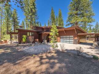 This stunning property boasts a modern architectural design with a warm, inviting wooden exterior.