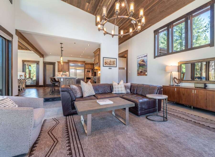 Step into luxury with this stunning property, featuring a spacious living area with a cozy leather sectional and a modern coffee table.