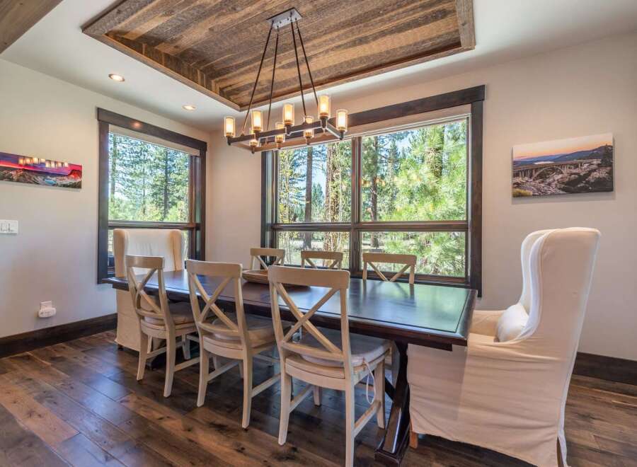 This stunning dining room boasts a rustic charm with its wooden ceiling and flooring, creating a warm and inviting atmosphere.