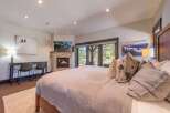 Experience luxury in this stunning bedroom featuring a cozy fireplace and a large bed, perfect for relaxation.