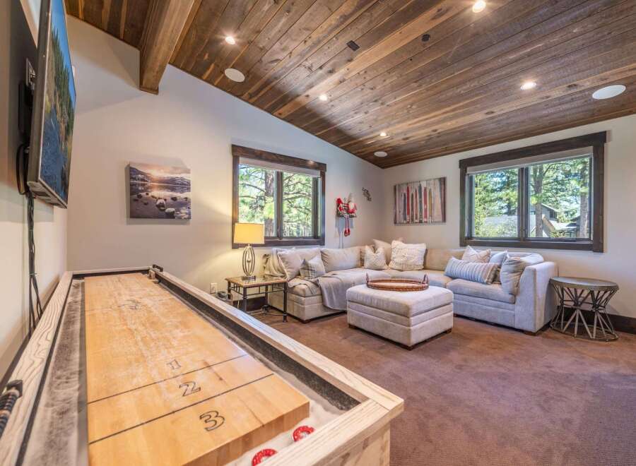 This stunning property boasts a cozy living area with a shuffleboard table, perfect for entertaining guests.