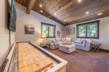 This stunning property boasts a cozy living area with a shuffleboard table, perfect for entertaining guests.
