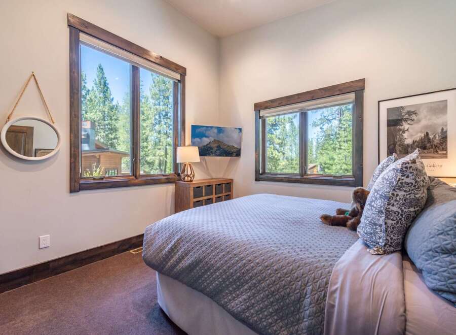 Experience the tranquility of this stunning bedroom, featuring expansive windows that frame breathtaking views of lush greenery.