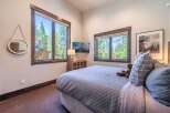 Experience the tranquility of this stunning bedroom, featuring expansive windows that frame breathtaking views of lush greenery.