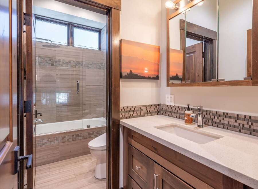 Step into this beautifully designed bathroom, featuring a modern vanity and a stunning sunset-themed artwork.