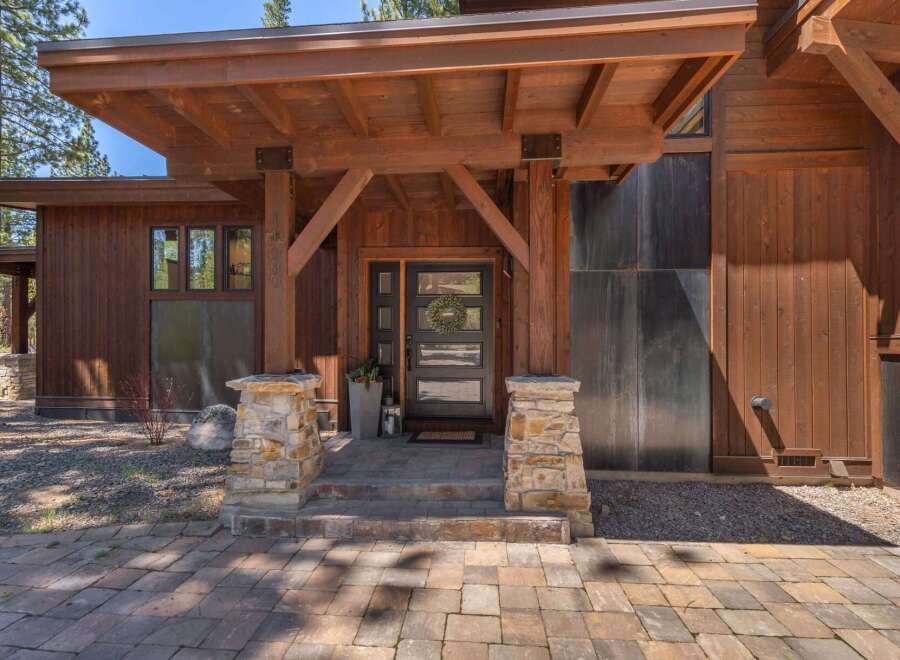 This stunning property boasts a beautiful wooden exterior and a welcoming entrance.