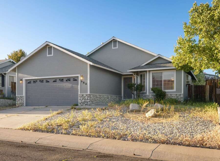 Charming home with a welcoming facade, featuring a gray exterior and a well-maintained front yard.