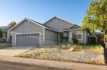 Charming home with a welcoming facade, featuring a gray exterior and a well-maintained front yard.