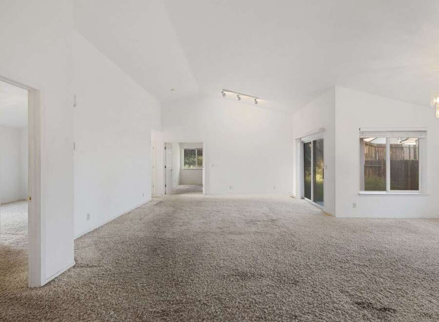 Step into this bright and airy living space, featuring a vaulted ceiling that enhances the sense of openness.